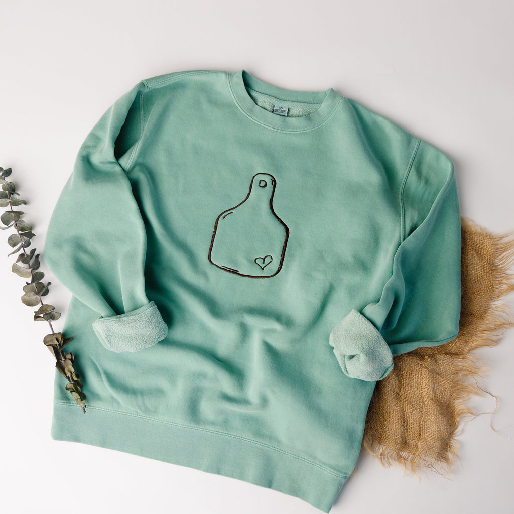 Mint green sweatshirt with a design on a white background