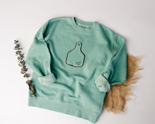 Mint green sweatshirt with a design on a white background