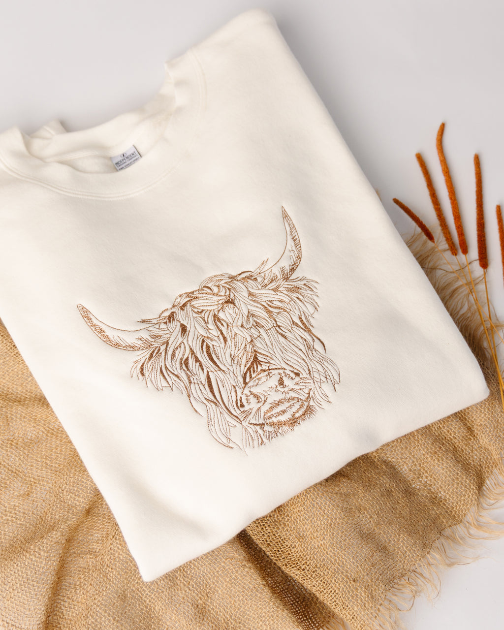 Beige towel with embroidered lion design on a textured surface