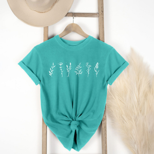 teal  t-shirt with floral designs on a hanger against a white background