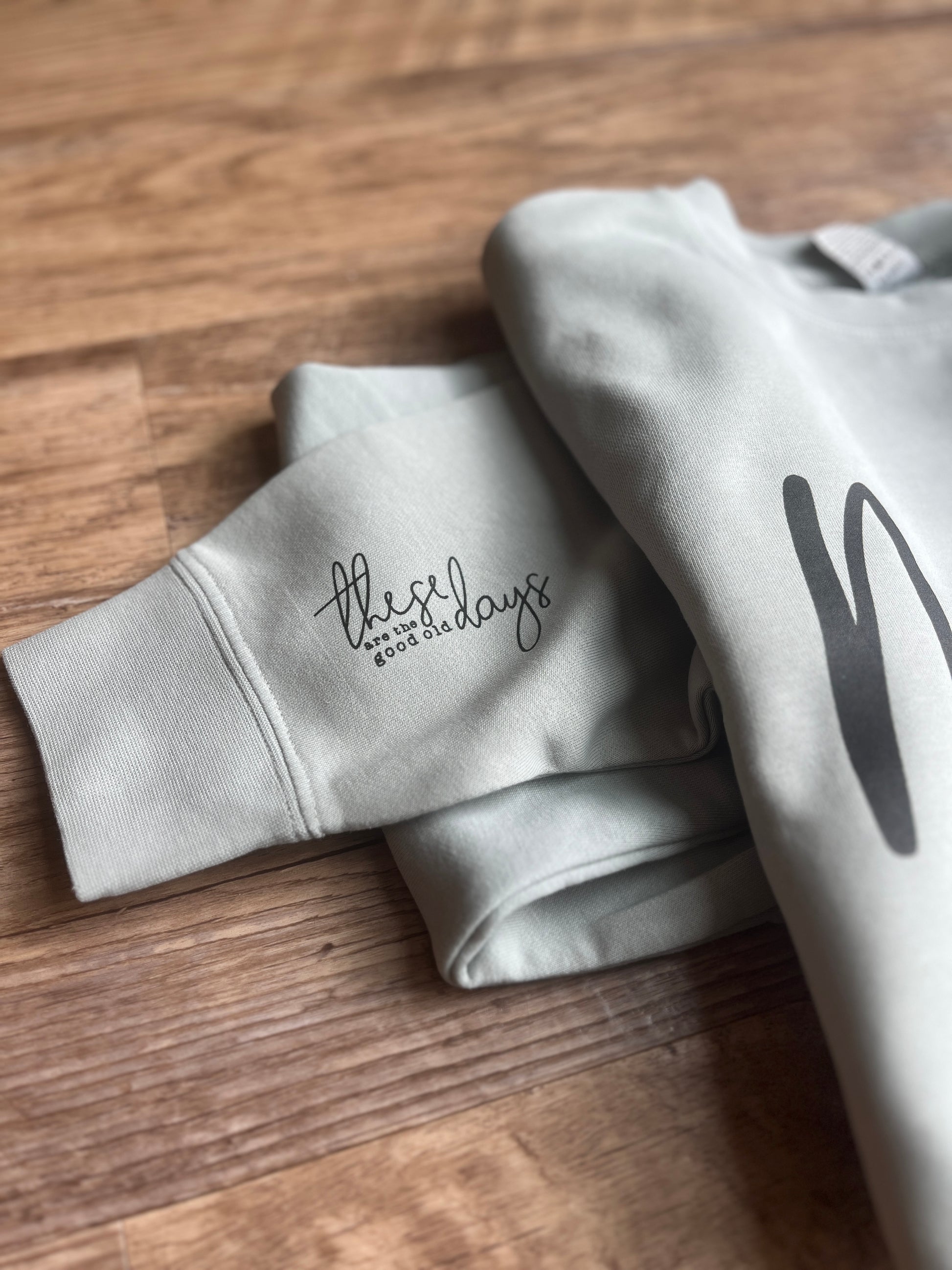 Gray sweatshirt with text on a wooden surface