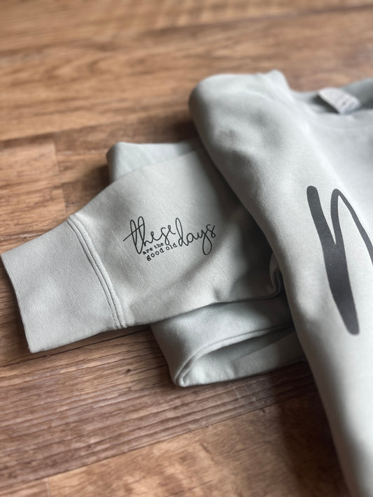 Gray sweatshirt with text on a wooden surface