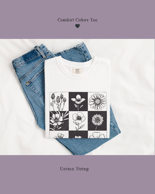 White t-shirt with floral design and matching cap on a wooden surface