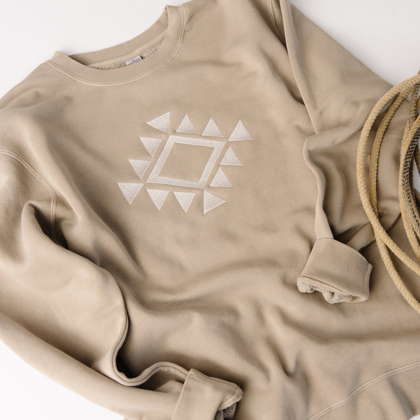 Beige sweatshirt with a geometric pattern on a white background