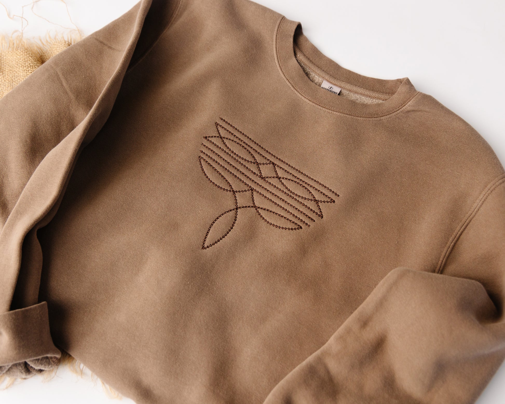Brown sweatshirt with a western design on a white background