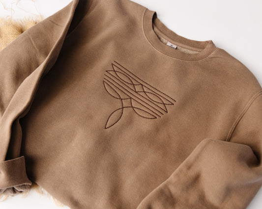 Brown sweatshirt with a western design on a white background