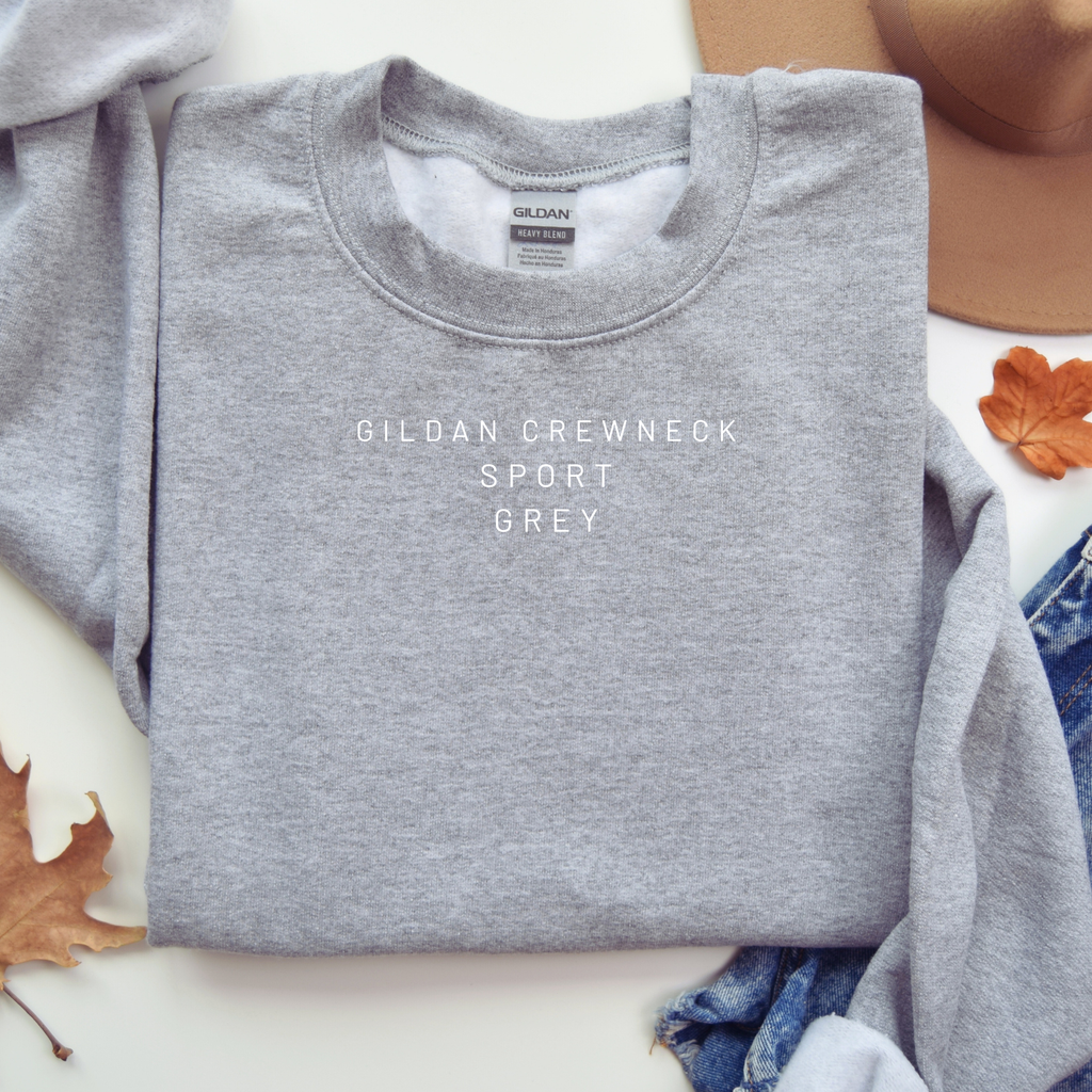 Folded gray Gildan sweatshirt with visible brand label on a white surface.