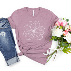 Mauve t-shirt with floral design, paired with jeans and flowers on a white background